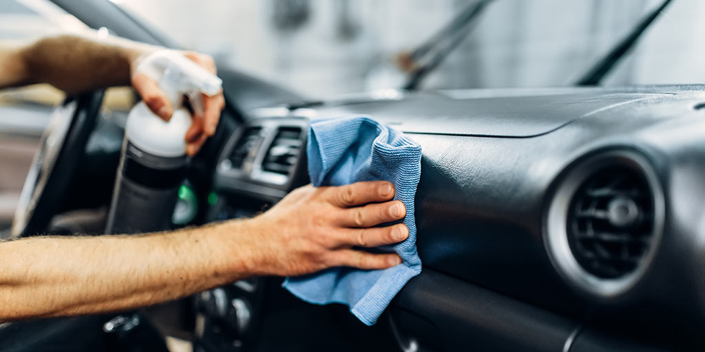 Das Fahrzeuginnere wird mit Reiniger und Tuch behandelt